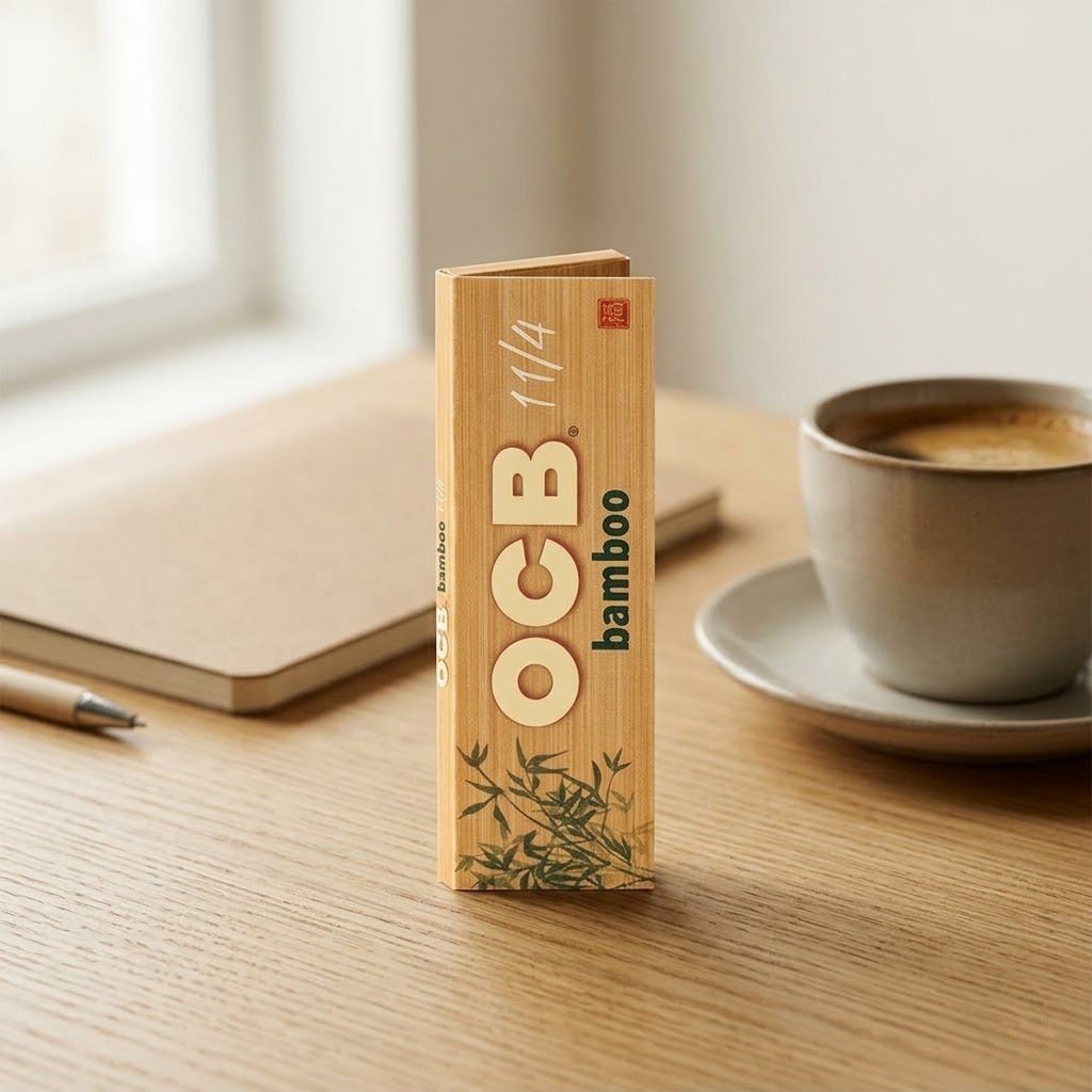 Cueros Papeles OCB Bamboo #9 de pie sobre una mesa de madera junto a una taza de café