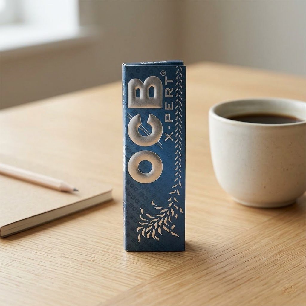 Cueros Papeles OCB X-Pert Blue #7 de pie sobre una mesa de madera junto a una taza de café